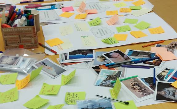 Pens, photos and sticky notes on a table